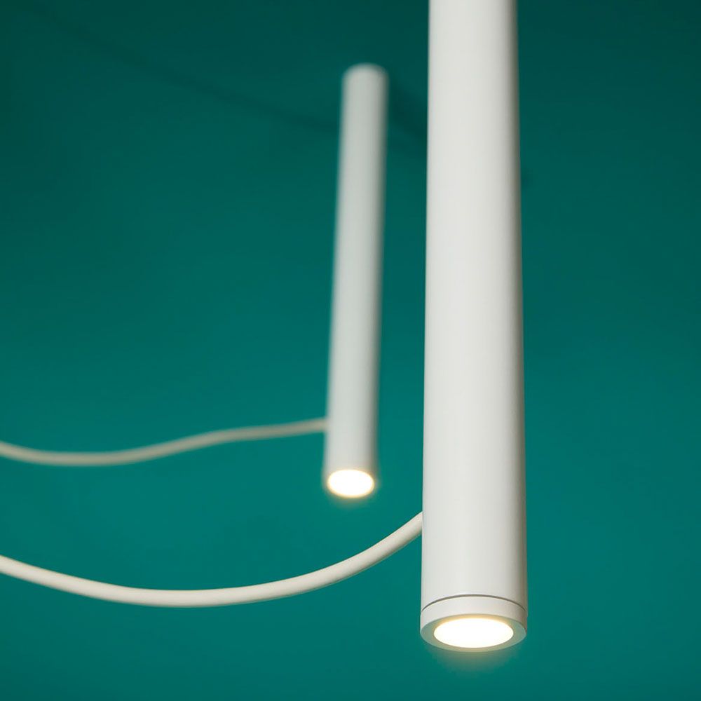 Fabbian Ari LED-Pendelleuchte 3-flammig mit weißen Röhren und schwarzen PVC-Kabeln.