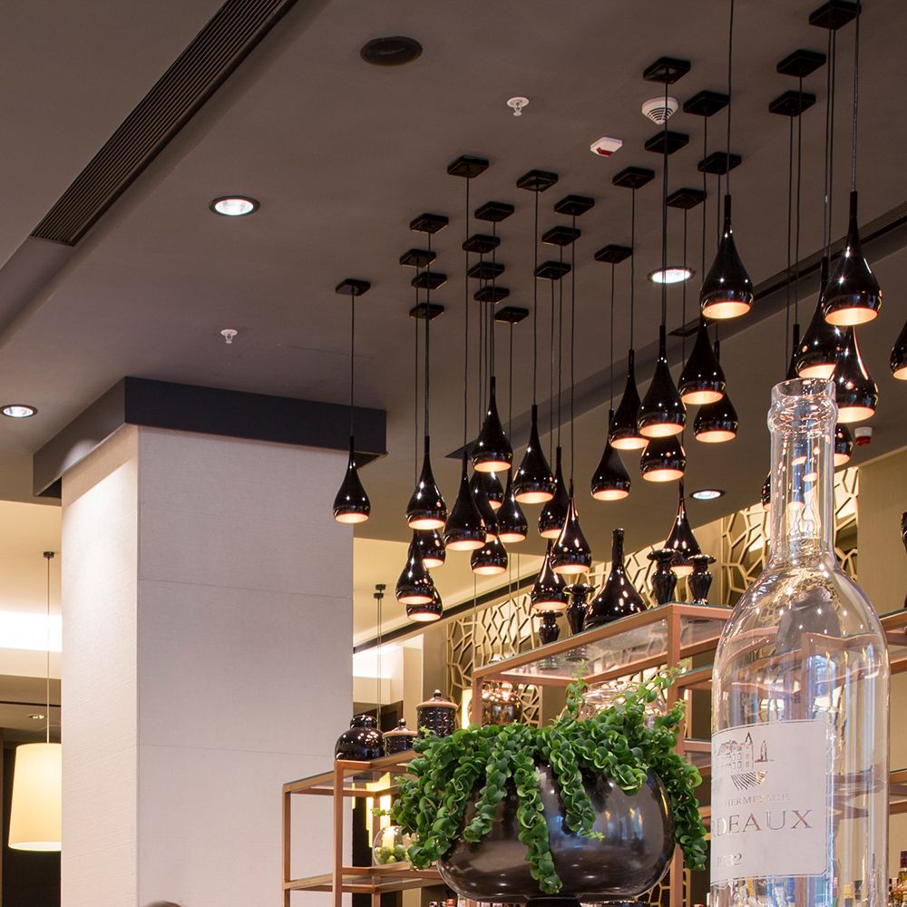 Moderne Fabbian Bijou Hängeleuchte Mini GU10 in einem stilvollen Restaurant über einer Bar.