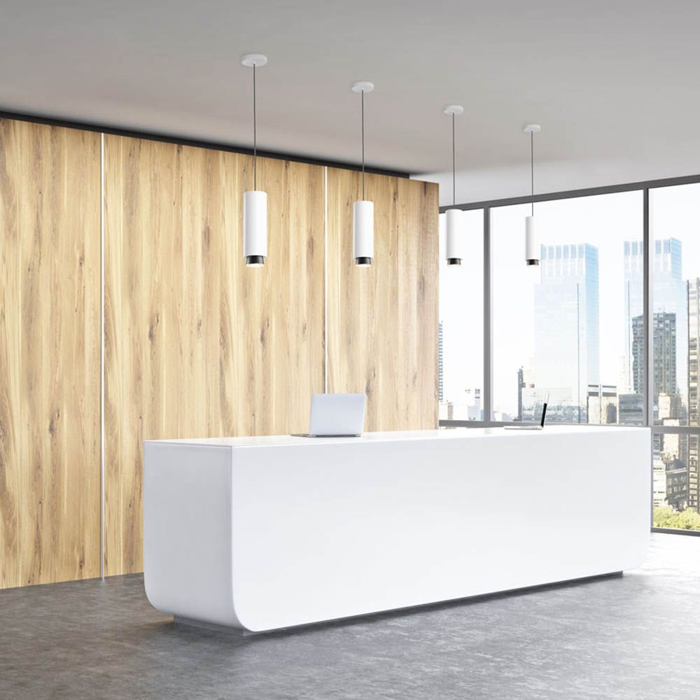 Helle Empfangstheke mit Fabbian Claque LED-Pendelleuchte Medium 20cm und modernem Interieur.