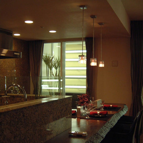 Modern kitchen lighting with the Fabbian Cubetto pendant light above a dining table.