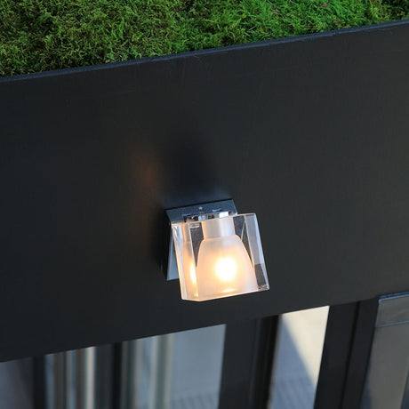 Fabbian Cubetto wall spotlight GU10 mounted on a wall, with a transparent diffuser and decorative light effect.