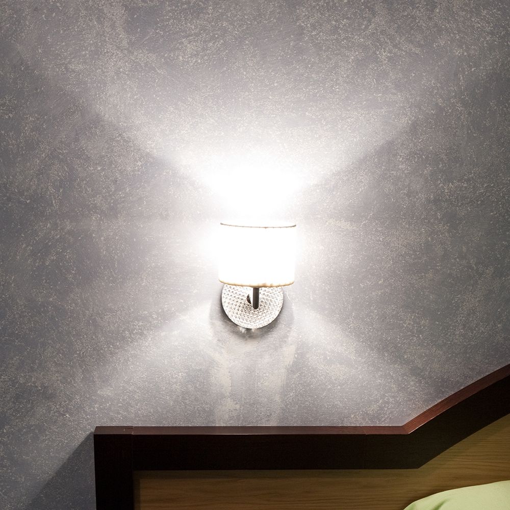 Fabbian Diamond&Swirl Wandlampe an einer Wand mit warmem Licht, perfekt für elegante Wohnräume.
