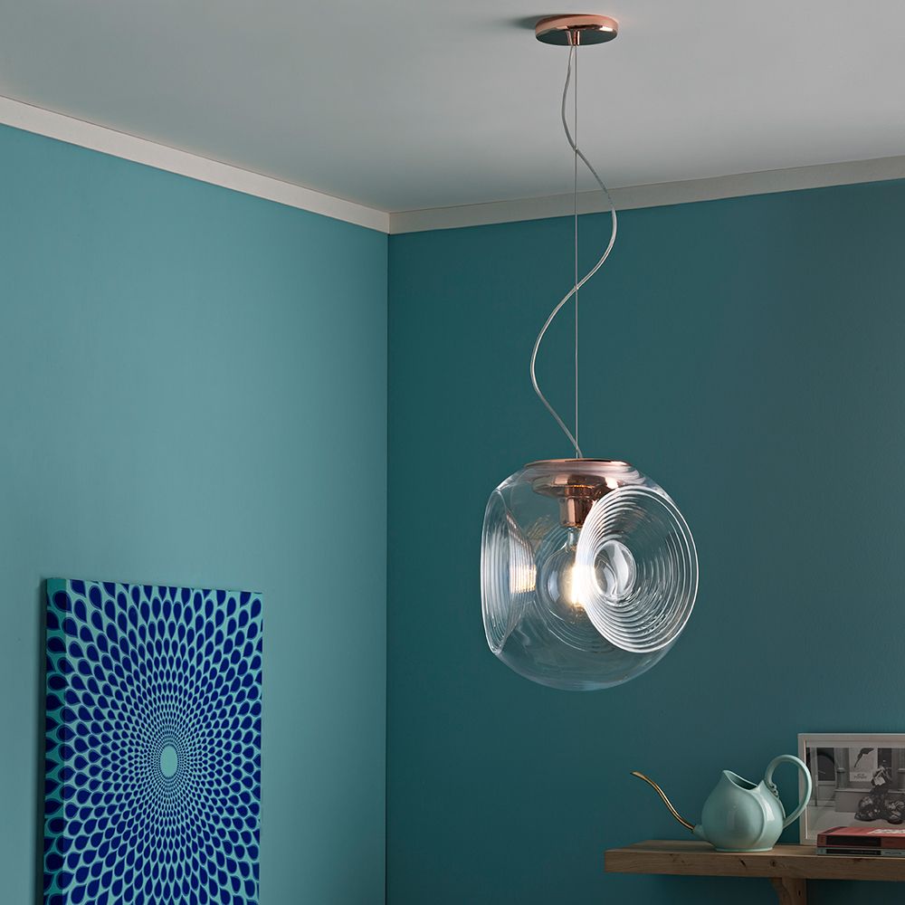 Fabbian Eyes Pendelleuchte Ø 35cm in modernem Wohnraum mit Kupferdetails und blauem Hintergrund