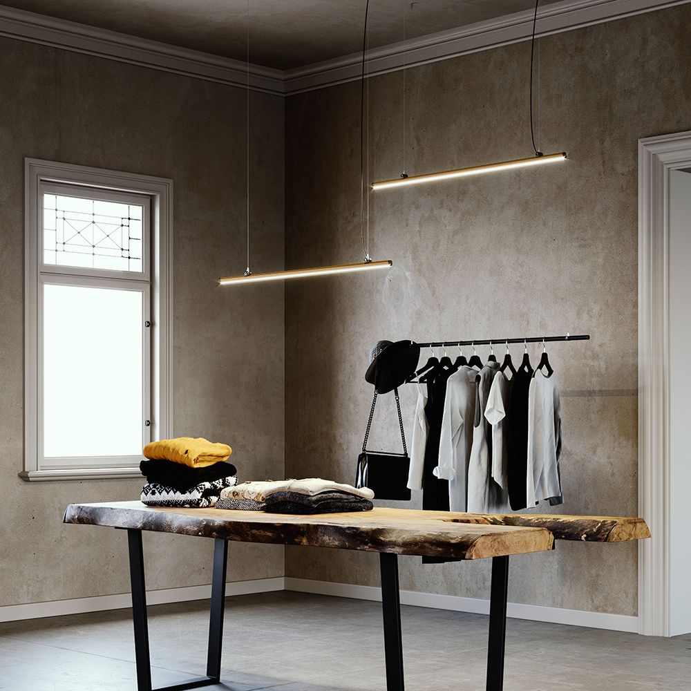 Fabbian Freeline LED-Hängeleuchte Long 300cm in einem stilvollen Raum über einer Holzfläche.