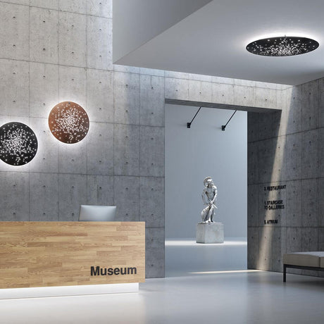 Fabbian Lens LED-Wandleuchte Ø 60cm in einer modernen Museumseinfahrt, harmonisch in die Architektur integriert.