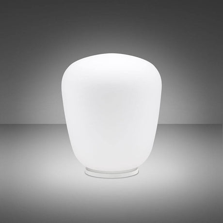 Fabbian Lumi Tischlampe Baka Ø 33cm aus weißem Glas auf einem Tisch, modernes Design für Wohnzimmer und Schlafzimmer.