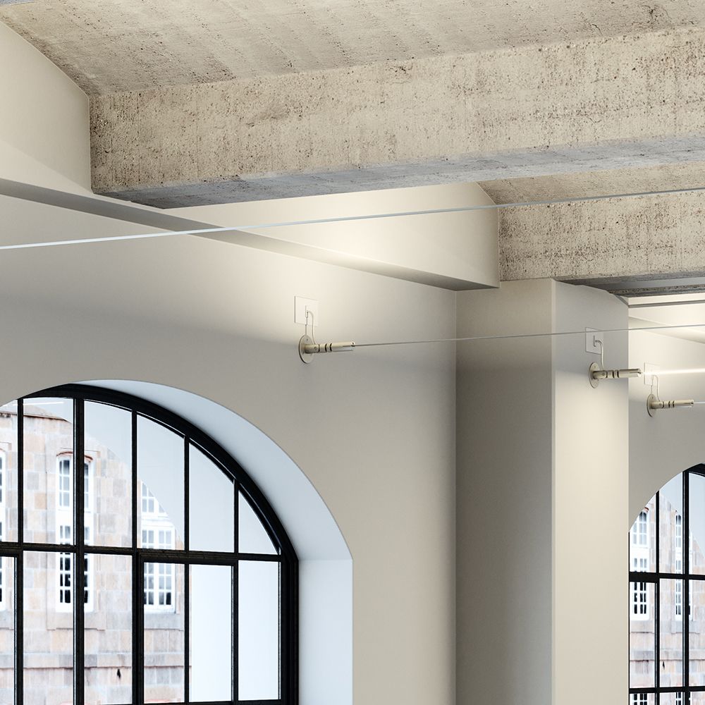 Eine moderne Innenansicht mit einer Fabbian Metro LED-Strip-Leuchte an der Decke in einem Raum mit großen Fenstern.