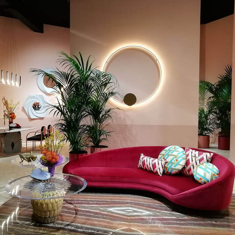 Moderner Wohnraum mit rotem Sofa, bunten Kissen und modernen Pflanzen.