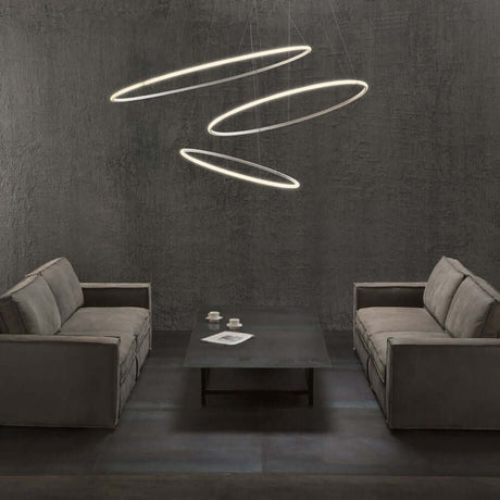 Fabbian Olympic Power LED pendant light 3-light in a modern living room above a coffee table.