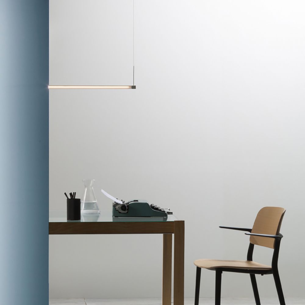 Moderne Fabbian Pivot LED-Hängeleuchte über einem eleganten Holztisch im minimalistischen Arbeitsbereich.
