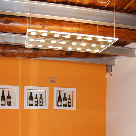 Fabbian Sospesa pendant light, 24-light, floats elegantly above an orange wall design.