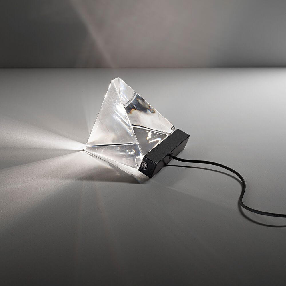 Fabbian Tripla LED-Tischleuchte in modernem Design, aus transparentem Material mit Schwarz und Lichtstrahl.