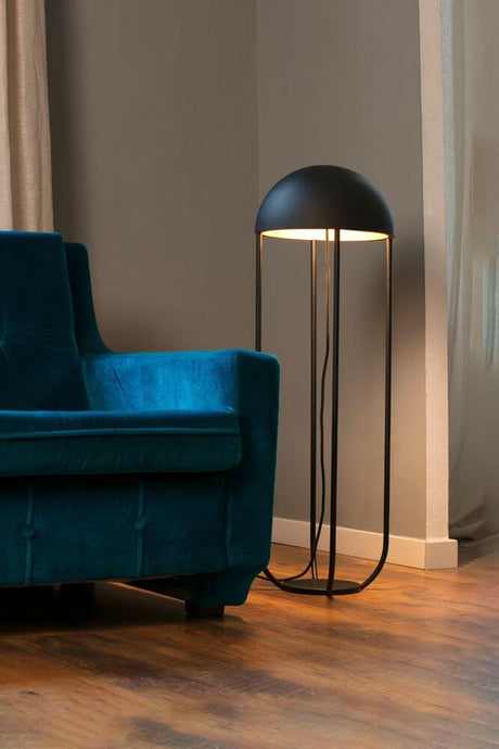 Jellyfish LED floor lamp black, gold stands next to a blue sofa in the living room.