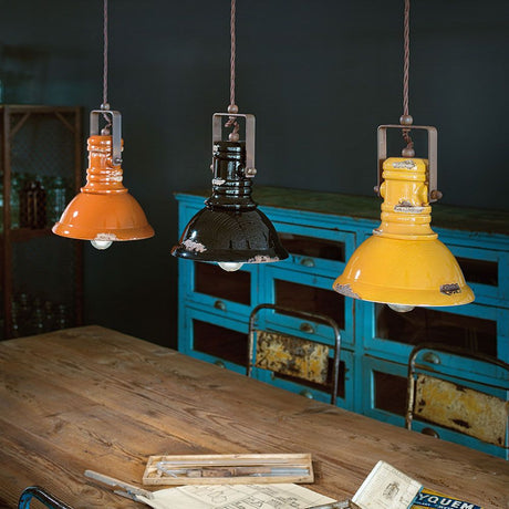 Ferroluce Industriel keramisk hængelampe Ø 23cm i orange, sort og gul over et bord.
