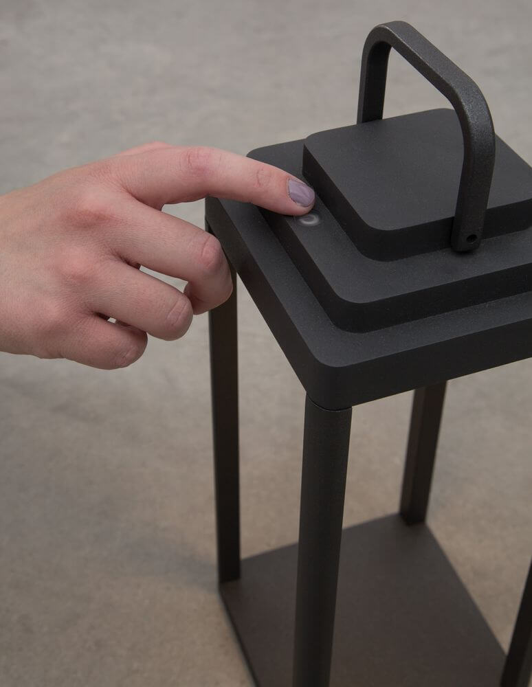 Nahaufnahme einer Hand, die die Figi LED Außenstehleuchte in Anthrazit einschaltet.