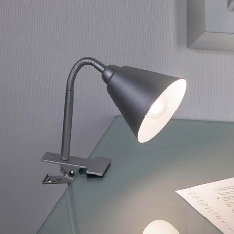 Flexible Klemmlampe Vitis Schnurschalter Grau auf einem Tisch, flexibel einstellbar für ideales Licht.
