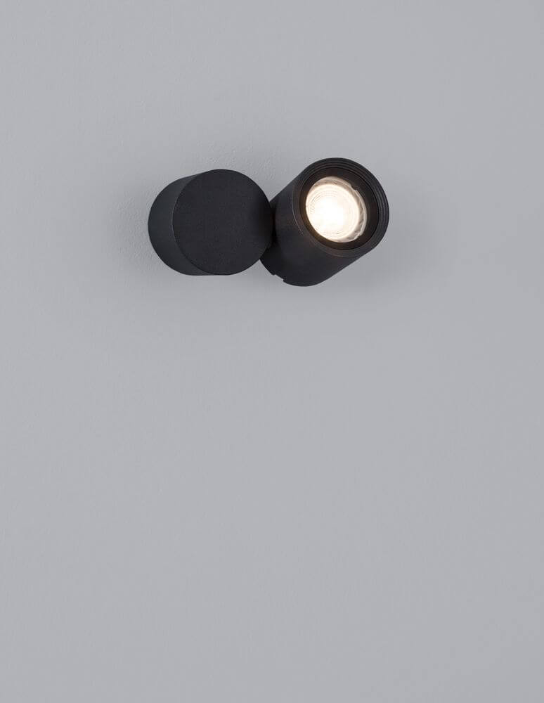 Focus Außenwandleuchte Rund GU10 Schwarz IP54 an einer grauen Wand montiert.