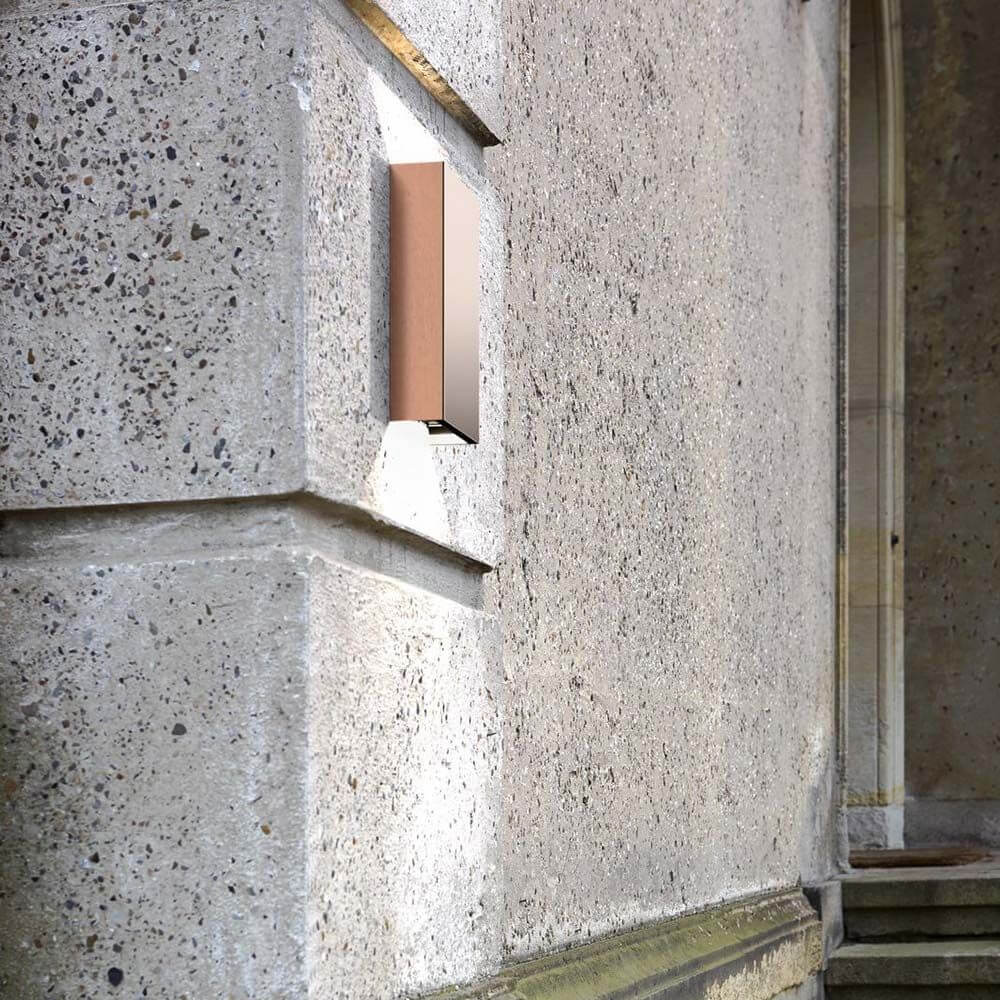 Fold 10 LED Wandleuchte aus Kupfer an einer Betonwand installiert, beleuchtet die Umgebung.