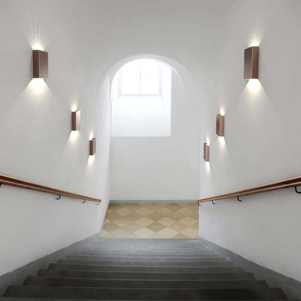 Moderne Fold 10 LED Außen-Wandleuchte in Kupfer, installiert an der Wand einer Treppe.