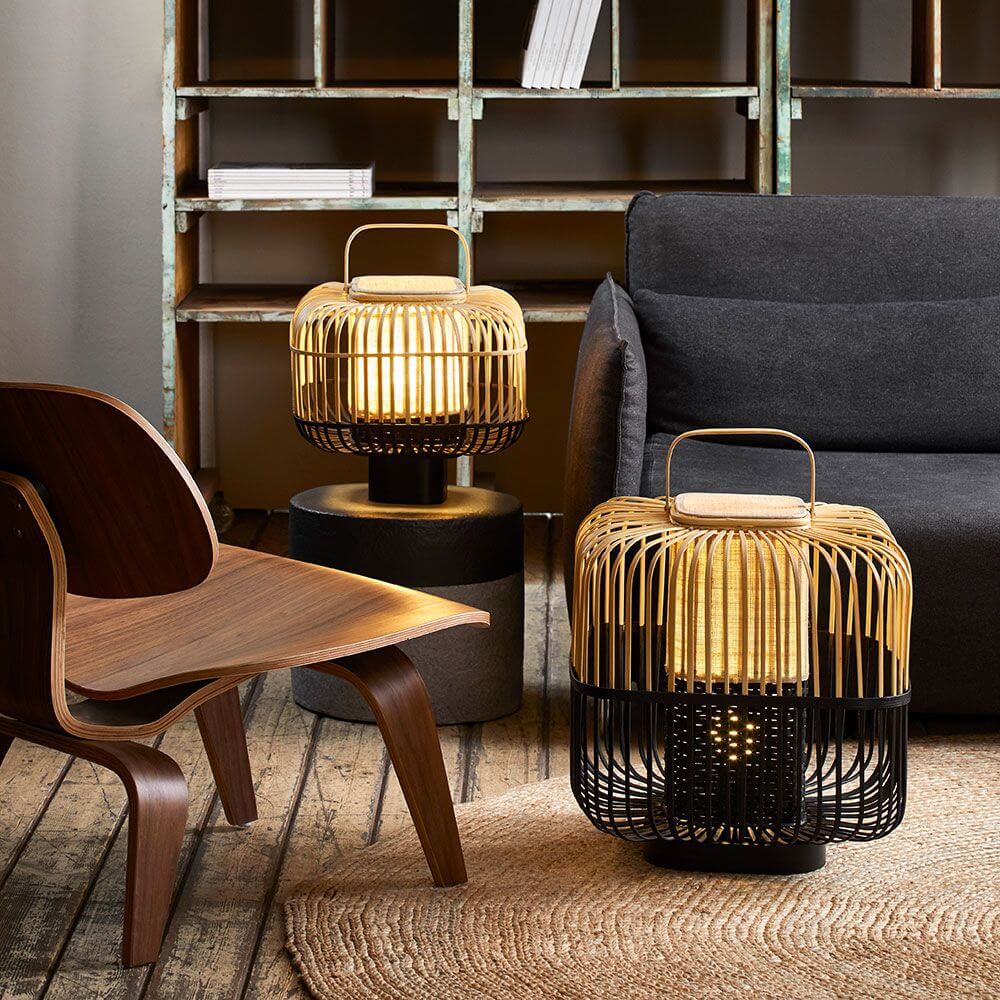 Forestier Bamboo Square Tischlampe in einem modernen Wohnambiente mit Holzstuhl und Couch.