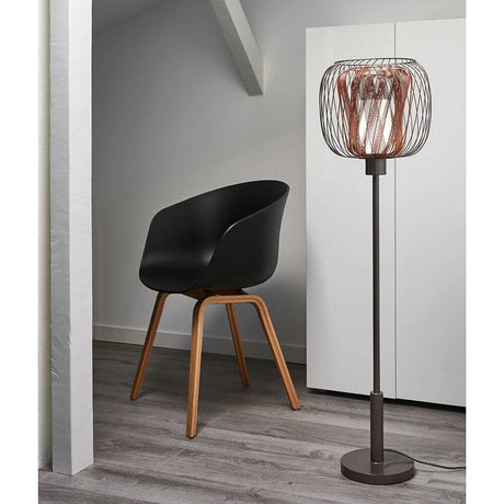 Forestier Design-Stehlampe Bodyless neben einem modernen schwarzen Stuhl in einem eleganten Raum.