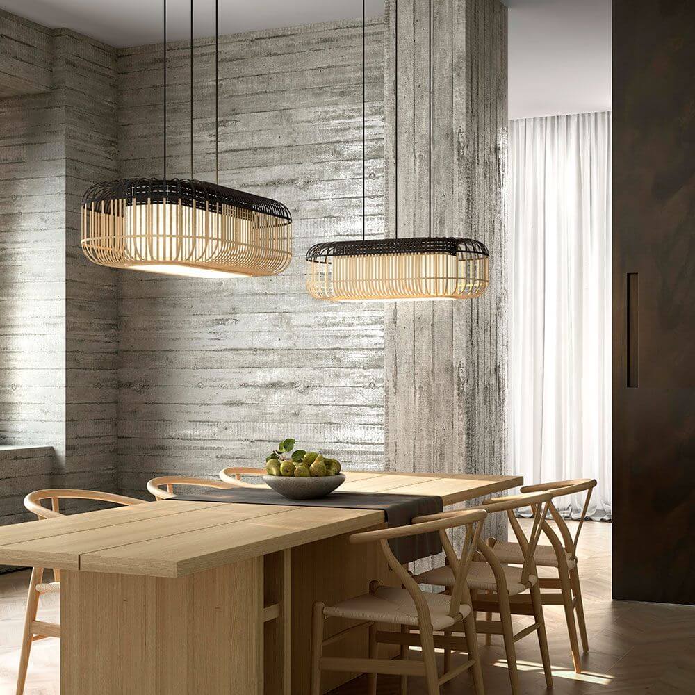 Forestier Esstisch-Hängeleuchte Bamboo Oval im modernen Zen-Stil über einem Holztisch mit Stühlen.