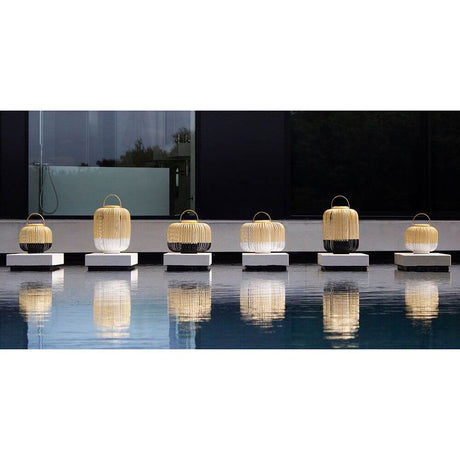 Forestier LED Akku-Bodenleuchte Take A Way IP66 auf einem Tisch am Pool, ideal für den Außenbereich.