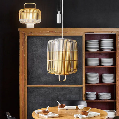 Forestier Pendelleuchte Bamboo Square in einem modernen Essbereich mit Holztisch und Geschirr.