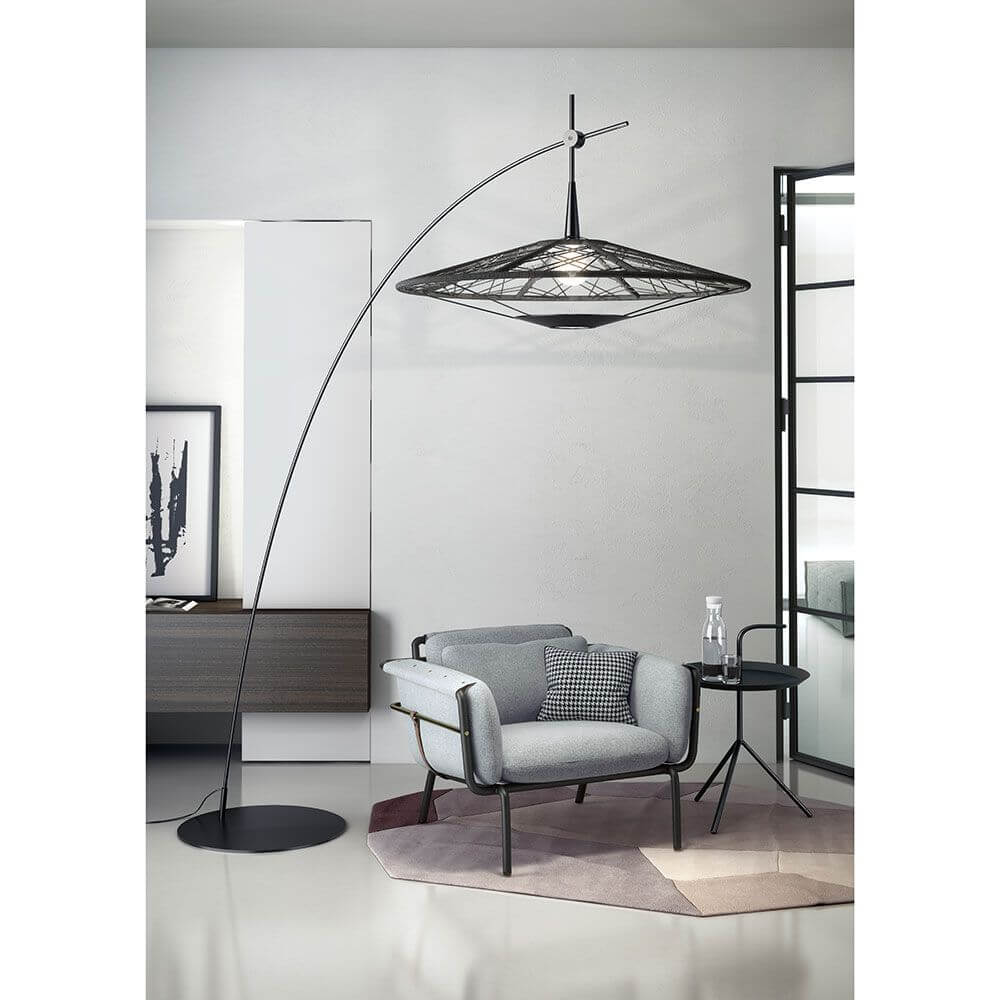 Forestier Stehlampe Carpa mit Trittschalter in modernem Wohnambiente neben einem bequemen Sessel.