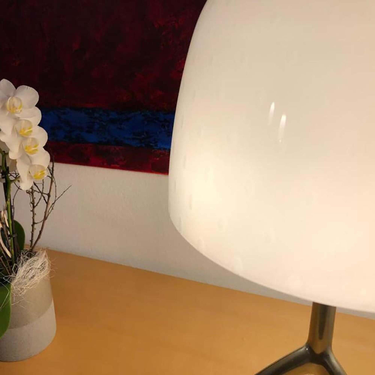 Lumiere 30th Grande Tavolo Tischleuchte Weiß auf einem Tisch, elegant mit Blumen im Hintergrund.