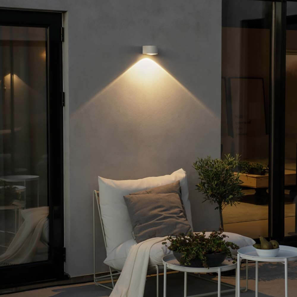 Gala LED Außen Wandleuchte Downlight an einer Hauswand mit gemütlicher Sitzgelegenheit im Freien.