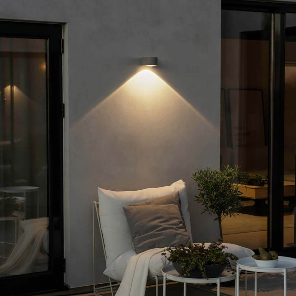 Gala LED Außen Wandleuchte Downlight an einer Wand mit sanftem Licht in einem modernen Außenbereich.