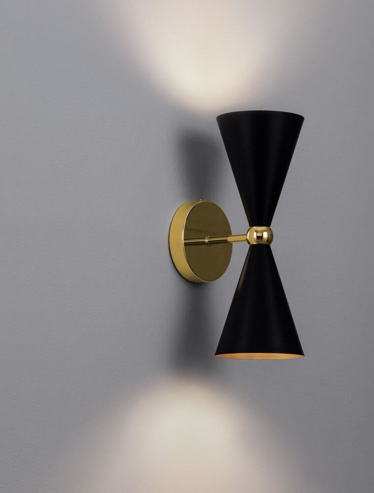 Gala Wandleuchte Gold, Schwarz an der Wand, modernes Design mit dekorativer Farbkombination.