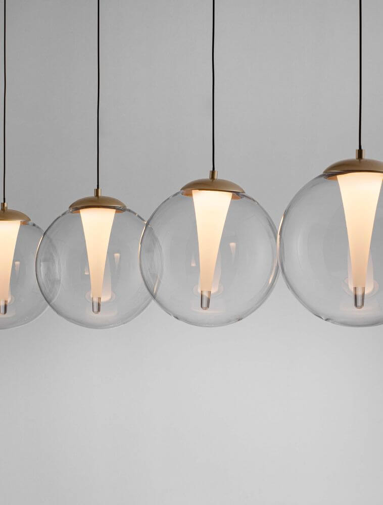 Galeo Pendelleuchte 4-flammig Balken 120cm 3000K Gold mit eleganten Glasabdeckungen und goldfarbenen Elementen.