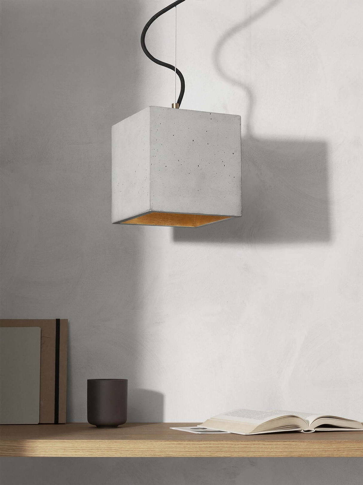 Gantlights B5 Beton Hängeleuchte in minimalistischer Einrichtung mit Beton- und Gold-Elementen.