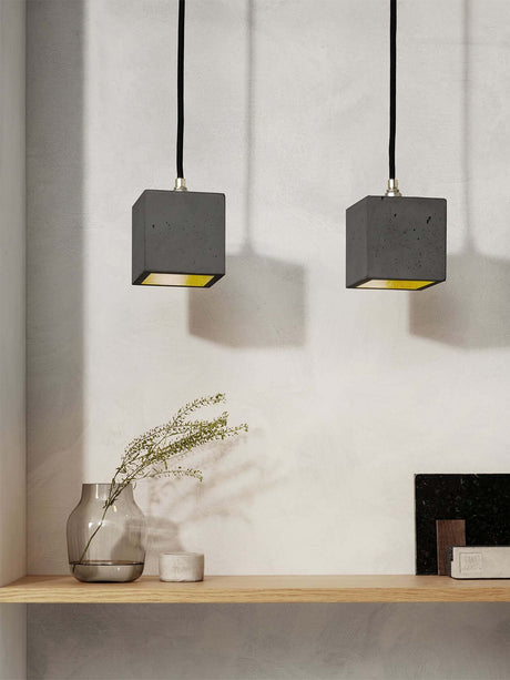Gantlights B6 Hängelampe Beton über einer Holzregal mit dekorativen Elementen