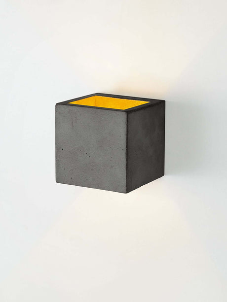 Gantlights B9 Wandleuchte Up & Down aus Beton mit goldener Innenseite und stimmungsvollem Licht.