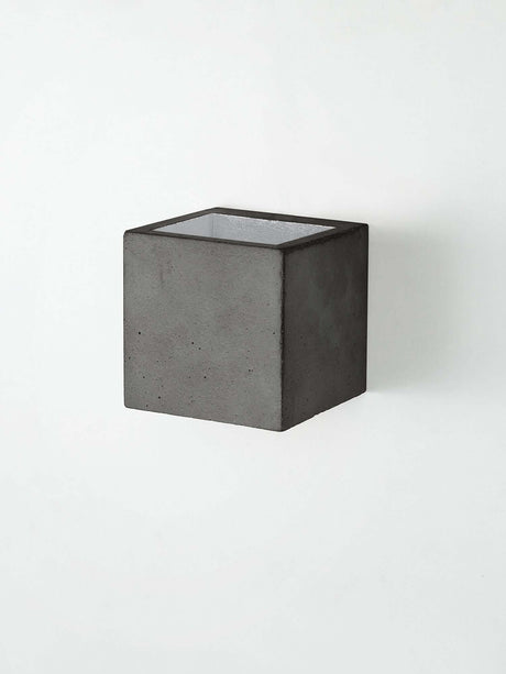 Gantlights B9 Wandleuchte Up & Down in quadratischem Design aus Beton an der Wand montiert.