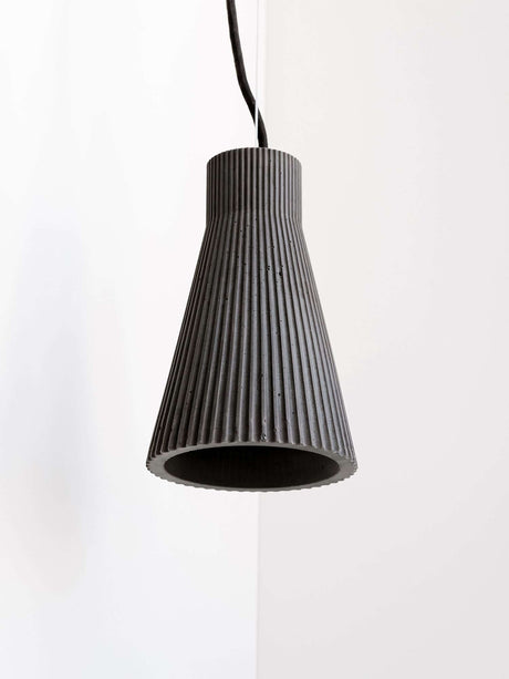 Gantlights S1 betongpendelampe med rillet design og unik rillet overflate, hengende i rommet.