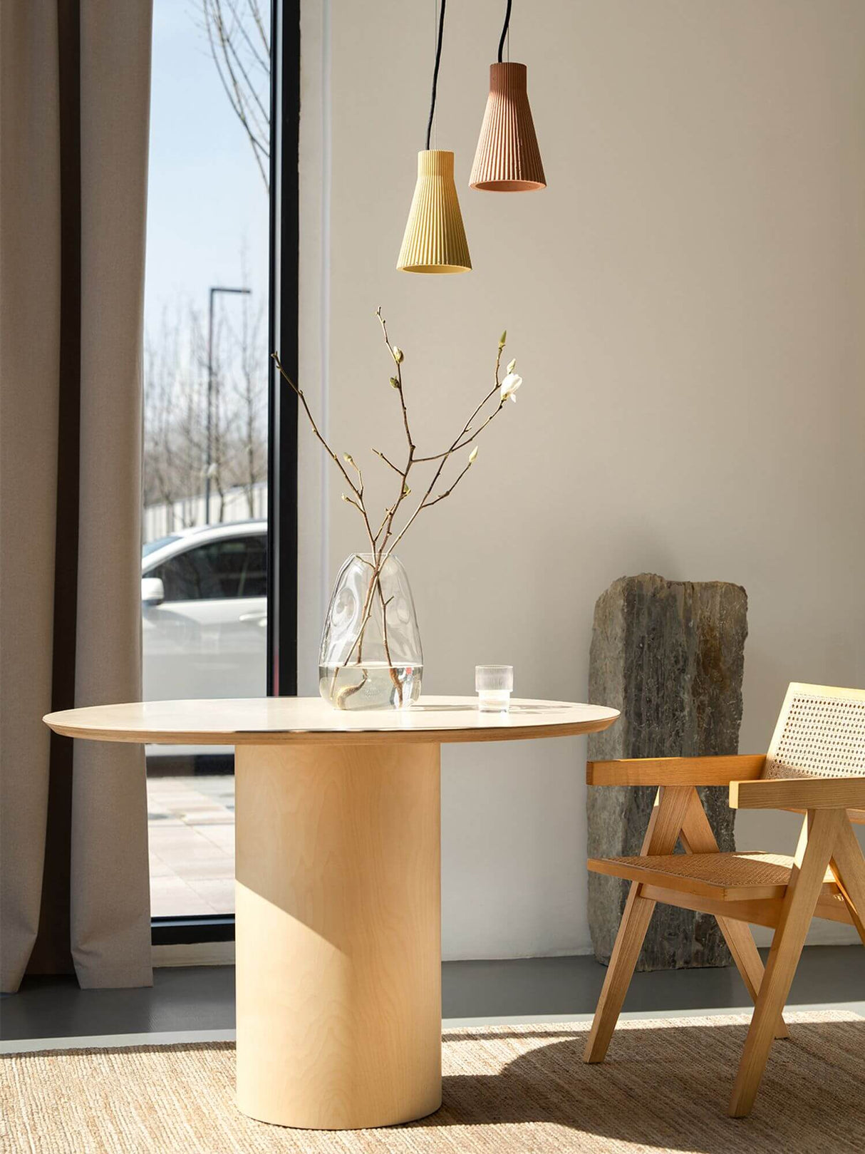 Gantlights S1 Beton Pendelleuchte geriffelt über einem modernen Tisch in einem hellen Raum mit klarer Aussicht.