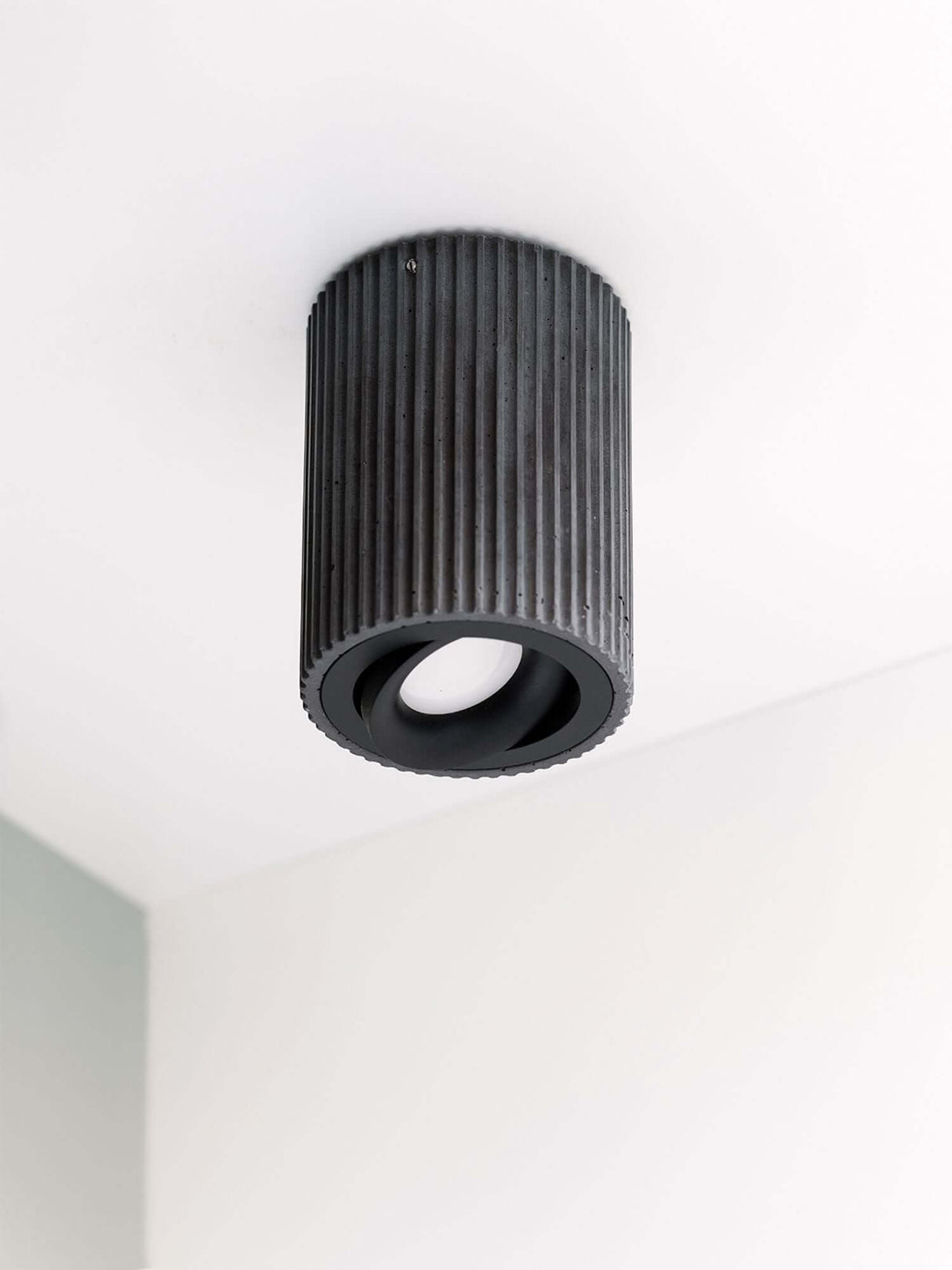 Gantlights S2 schwenkbarer Deckenspot Plissiert aus Beton mit gerillter Oberfläche an Decke montiert.