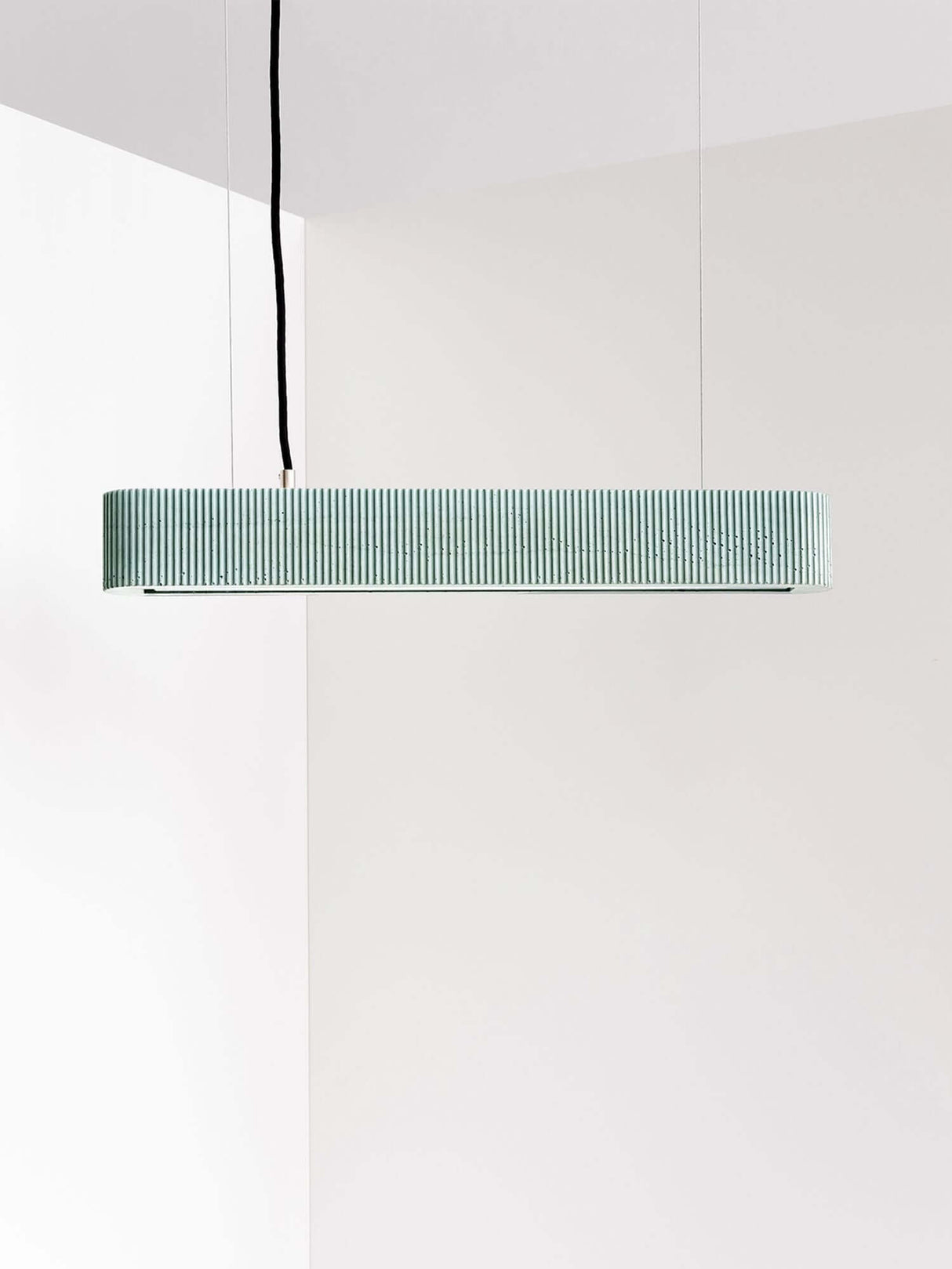 Gantlights S4 Beton LED-Pendelleuchte 61cm Plissiert an minimalistischer Decke in hellem Raum.
