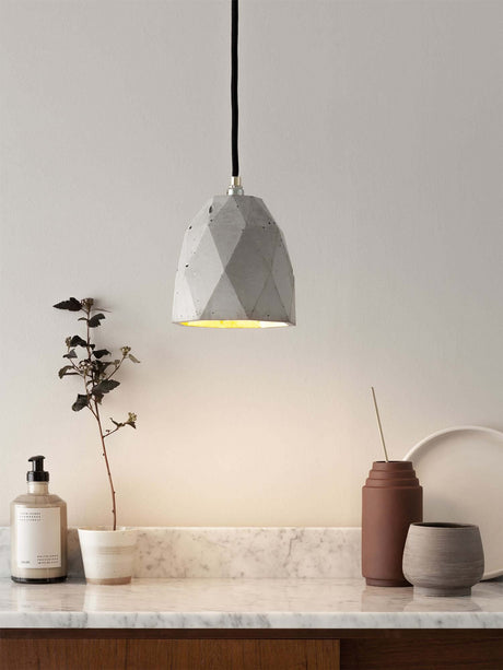 Gantlights T1 Pendelleuchte Beton in modernem, minimalistischem Interieur mit Marmorablage.