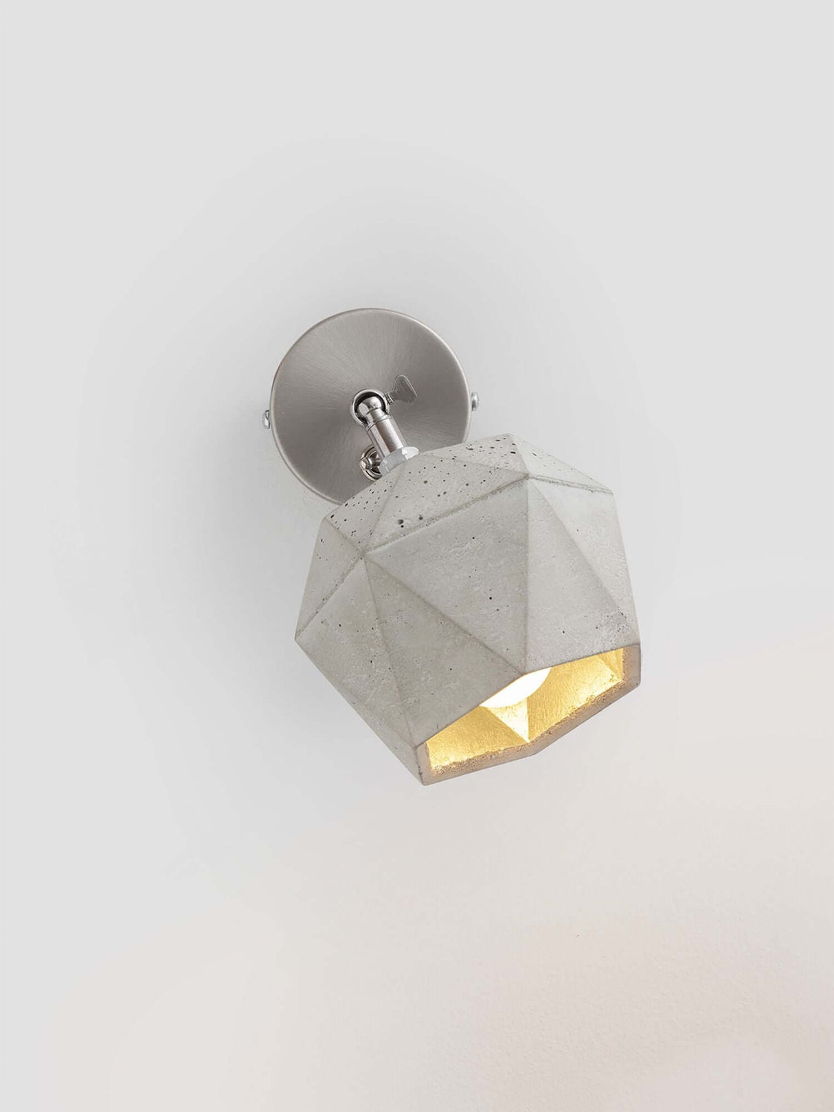 Gantlights T2 Wandspot Beton trianguliert in hellgrauem Beton mit warmem Licht, elegantes Design.