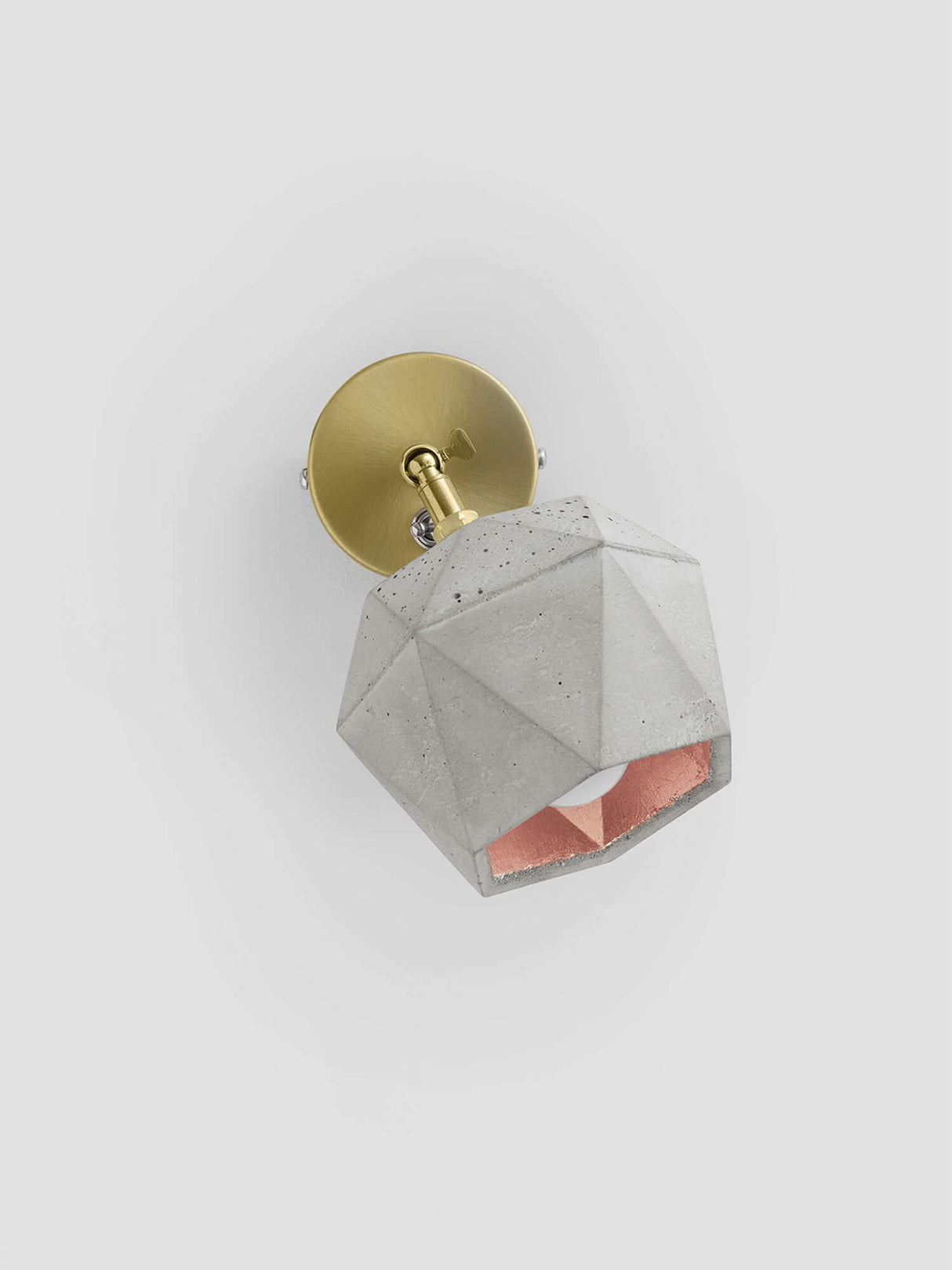Gantlights T2 Wandspot Beton trianguliert, moderne Wandlampe aus hellgrauem Beton mit goldenen und rosa Akzenten.