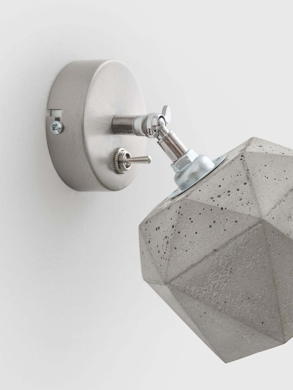 Gantlights T2 Wandspot Beton trianguliert an Wand montiert, aus hellgrauem Beton mit edlem Design.