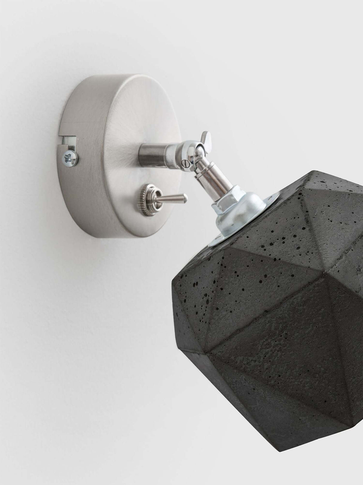 Gantlights T2 Wandspot Beton trianguliert an einer Wandmontage mit hochwertigem Design aus Beton und Metall.
