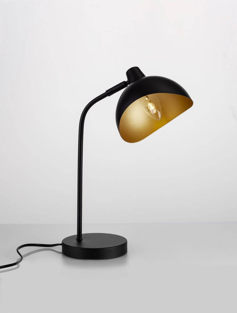 Geti Tischleuchte Schwarz, Gold mit modernem Design und atmosphärischer Lichtwirkung auf einem Tisch.