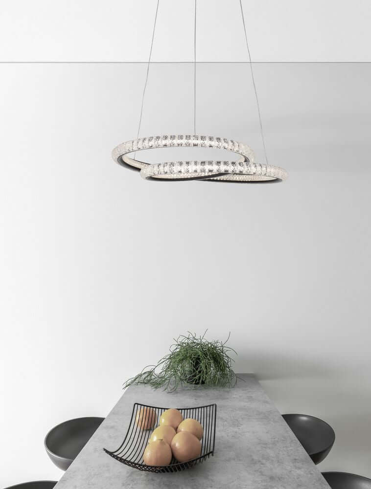 Ginevra LED Pendelleuchte Ø 48cm 3000K Schwarz über einem Tisch mit Obst und Pflanze.