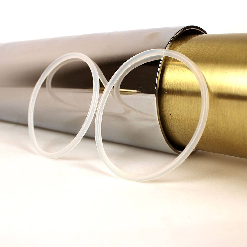 Zwei transparente Gummiringe für die s.luce Crutch Hängeleuchte auf silbernem und goldenem Hintergrund.